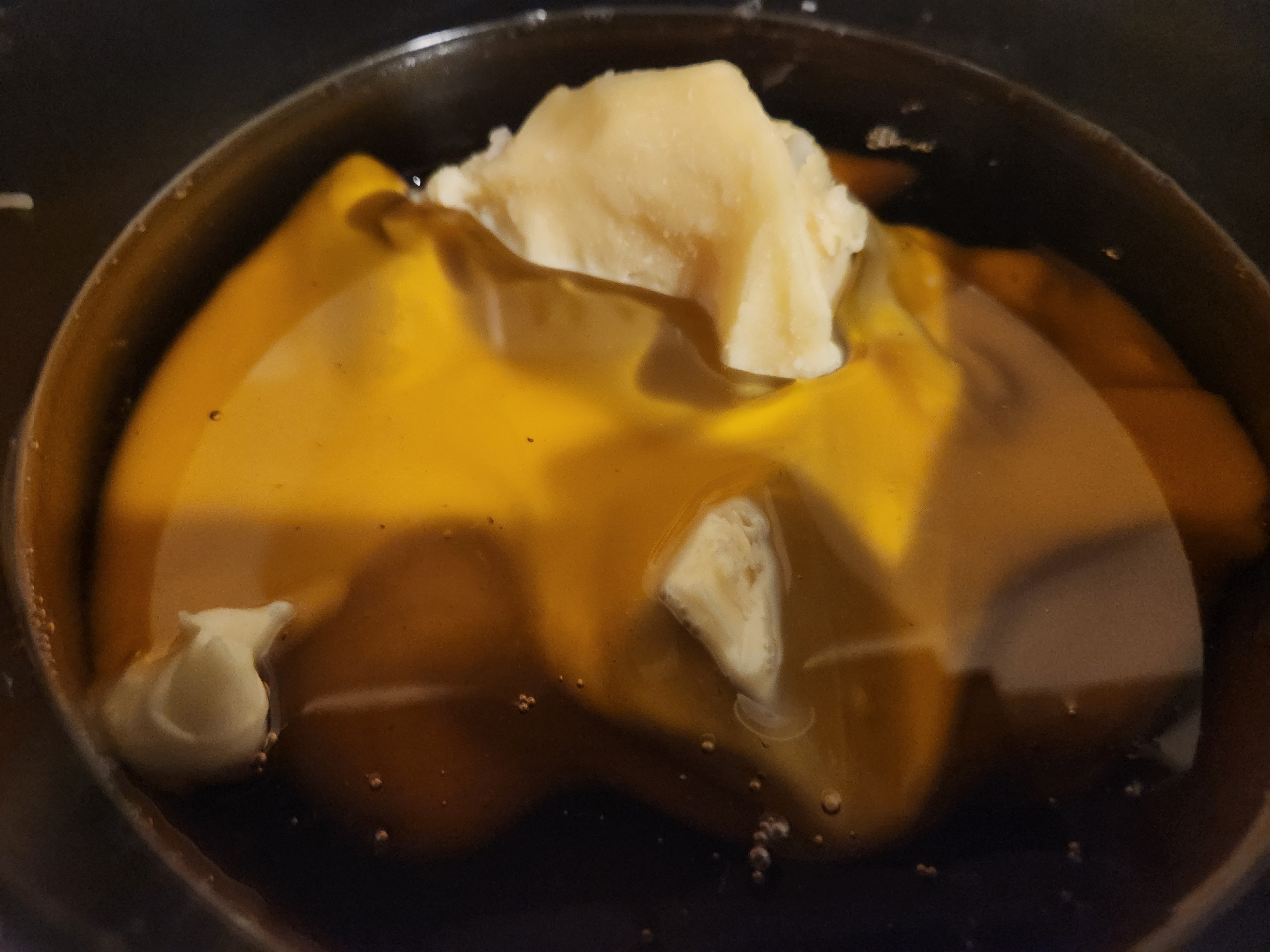 Raw organic American beeswax melting in a pan — the process behind every Beeswax Pat candle